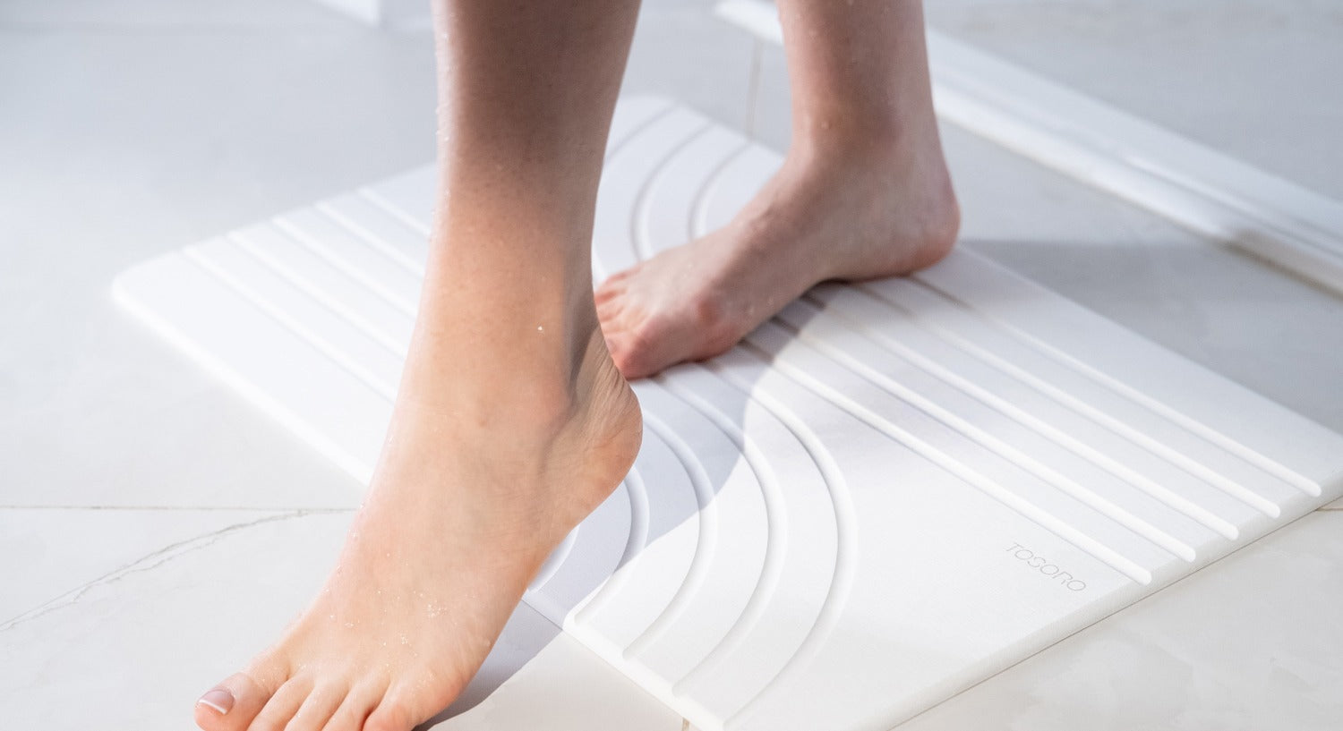 Stepping onto the TOSORO Flow Sandstone stone bath mat β our best seller β footprint drying on the stone